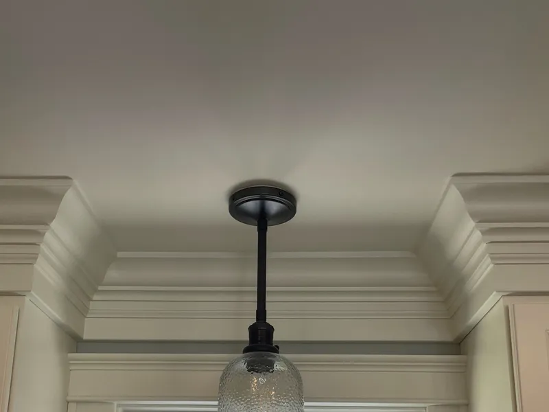 Built-up crown molding and painted window casing around a kitchen window